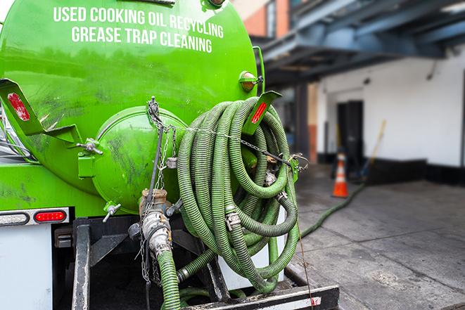 a professional technician pumping a restaurant's grease trap in Carmel By The Sea, CA